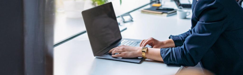 Млада жена работи на лаптоп в модерен офис.