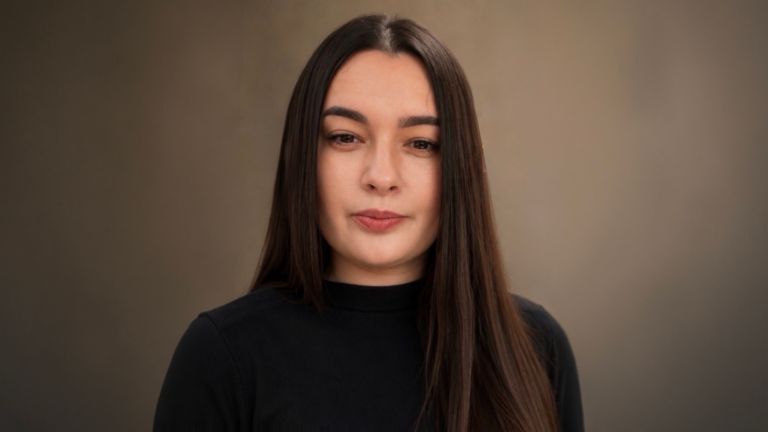 Daniela Moaca, Senior Manager IT в EOS Romania, портретна снимка с тъмен поло пуловер.