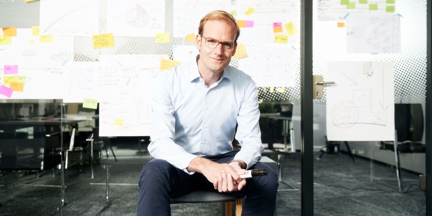 Receivables purchasing: Matthias Schmidt, Head of Operational Debt Purchase at EOS Group, sits in front of a wall covered in post-its and other notes.