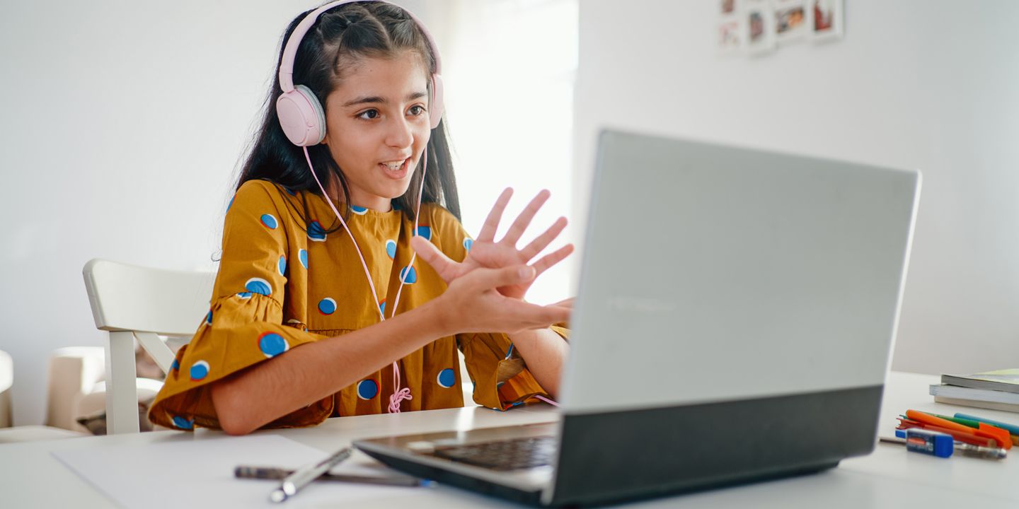 Financial literacy means responsibility: A girl sits at a laptop and takes part in online learning. 