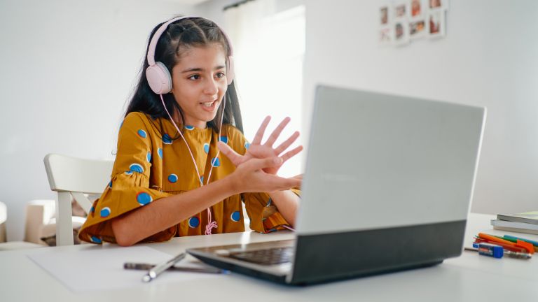 Financial literacy means responsibility: A girl sits at a laptop and takes part in online learning. 